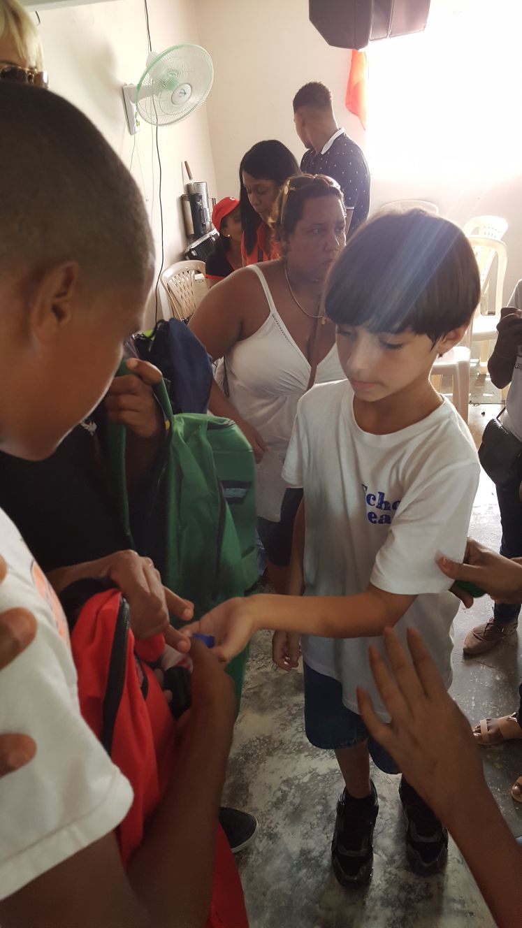 children giving backpack